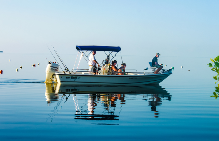 Family in fishing boat on very calm water where the ocean blends into the sky off Cudjoe Key Florida USA circa August 2010 S  By Svineyard
